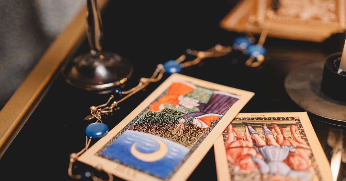 Mavi mumlarla çevrili tarot kartları ve mistik masa