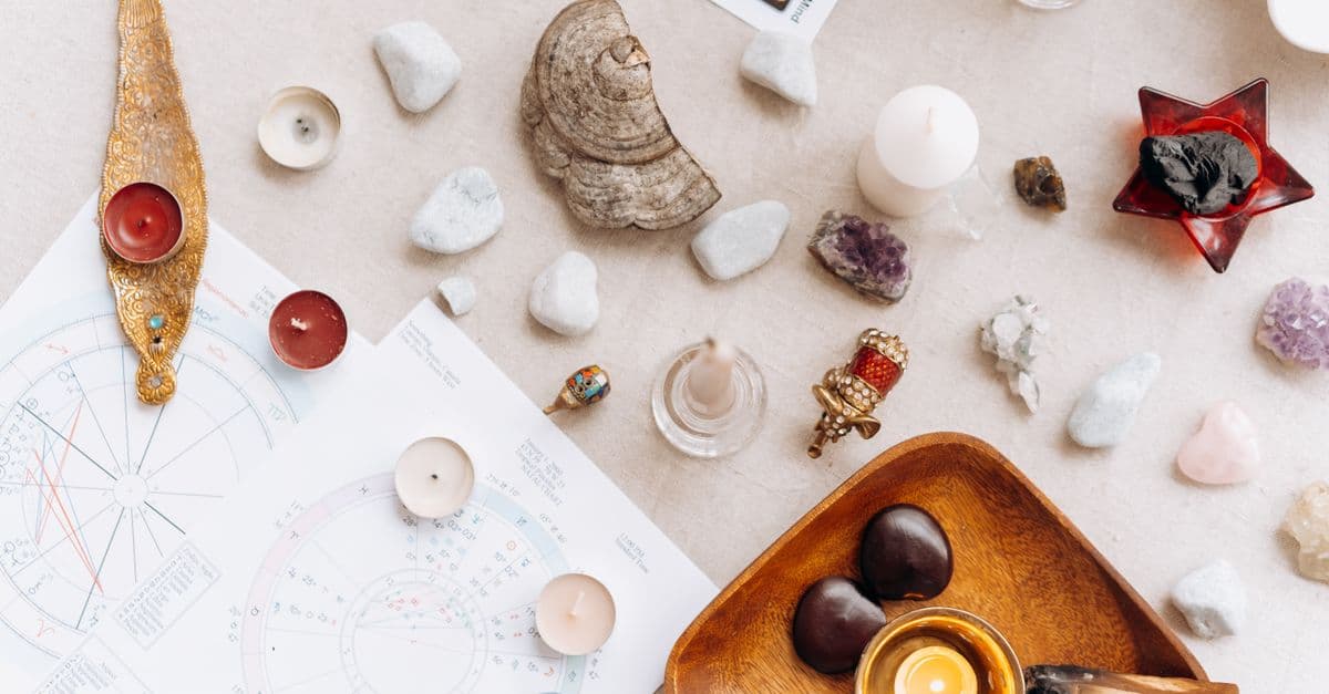Astroloji ve tarot temalı mumlar ve kristallerle hazırlanmış bir masa