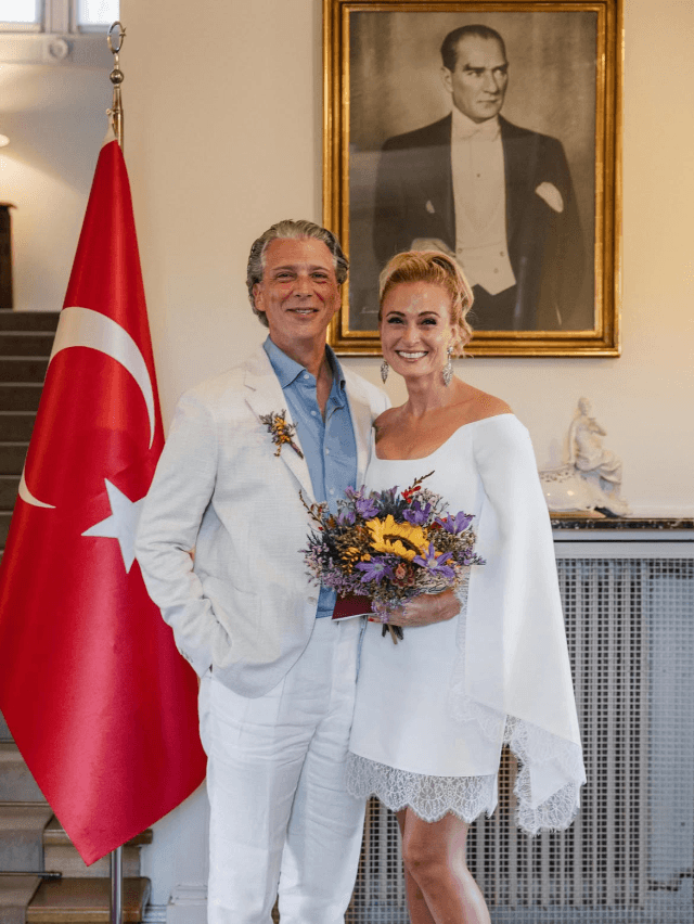 Ceyda Düvenci gülümserken, arka planda nikah fotoğrafı görünüyor