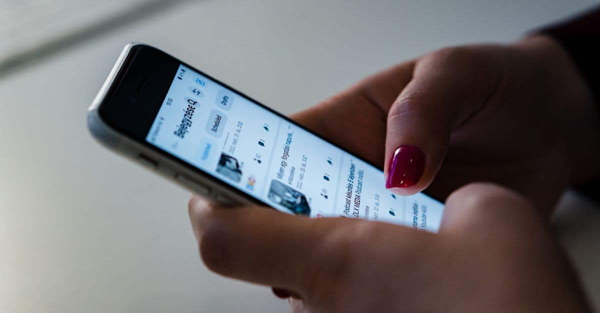 Bir kişinin telefon ekranında sosyal medya gündemini takip etmesi