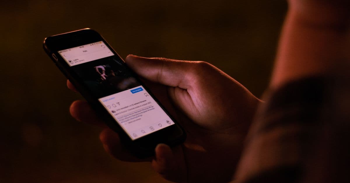 Telefon üzerinden sosyal medya paylaşımlarını takip eden bir kullanıcı