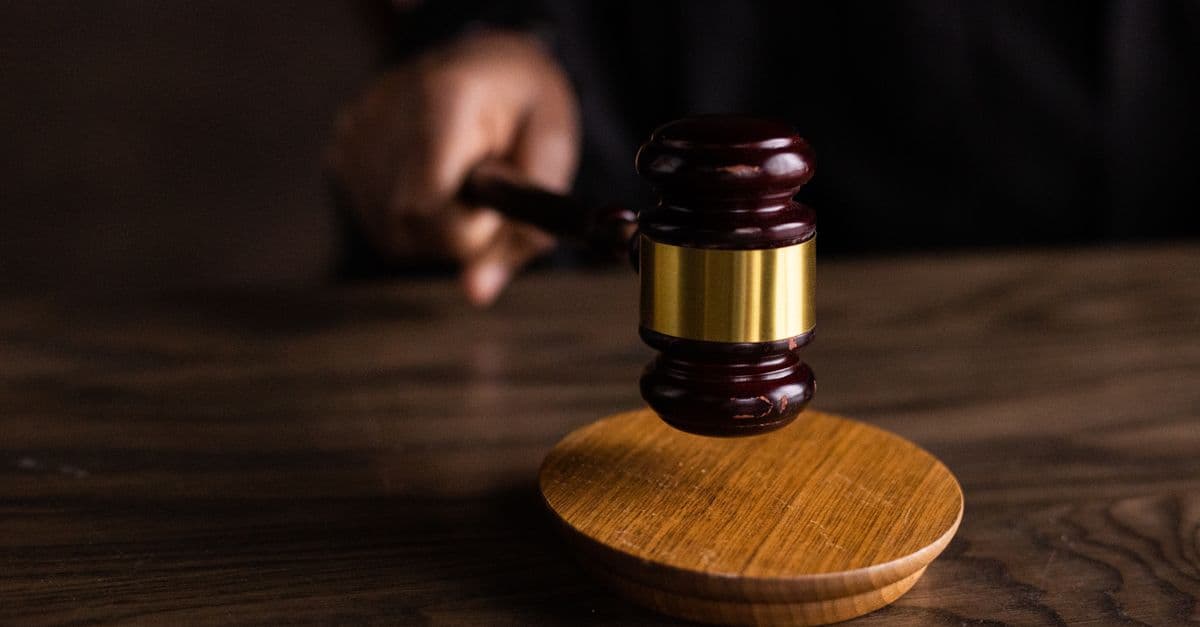 Bir mahkeme salonunda tokmak ve adalet terazisi simgesi