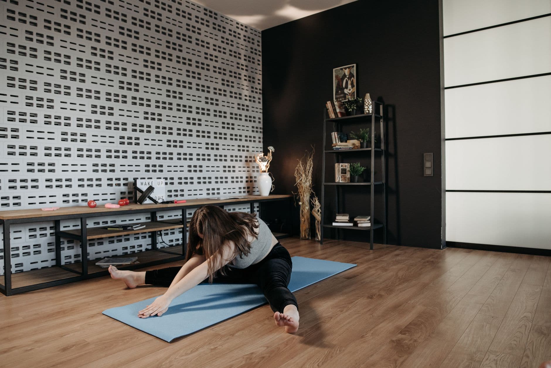 Evde mat üzerinde kontrollü Pilates hareketi yapan kadın