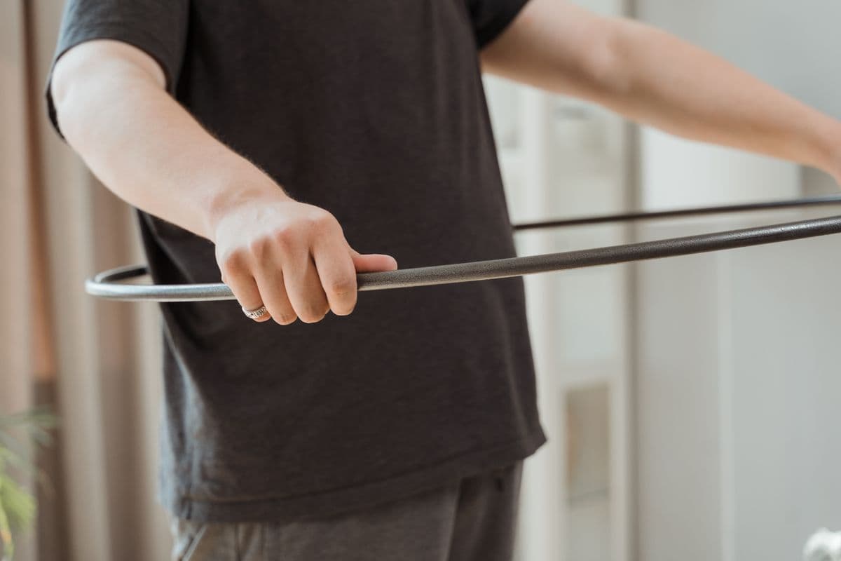 Kadın evde ağırlıklı hula hoop ile antrenman yaparken