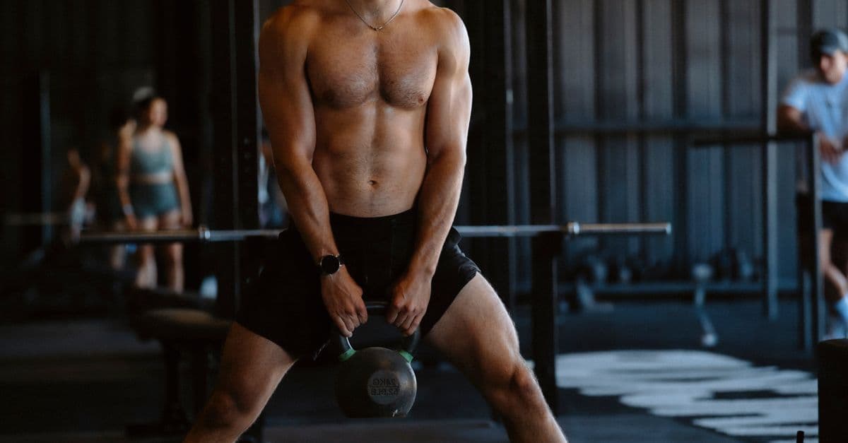 Kadın sporcu spor salonunda kettlebell ile antrenman yapıyor