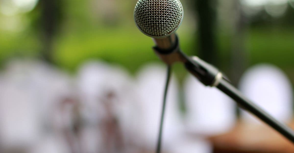 Sahne ışıkları altında mikrofon ile performans anı