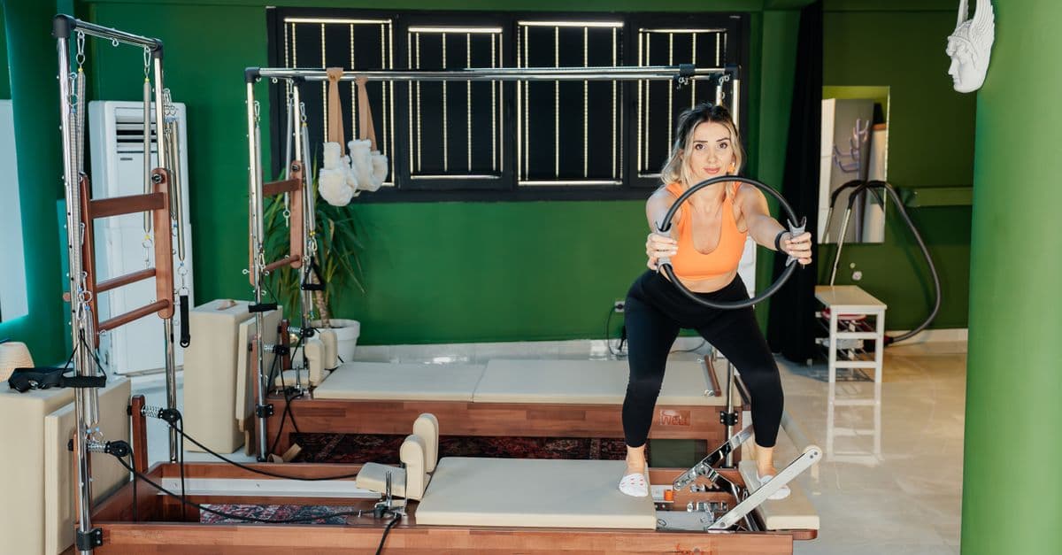 Mat üzerinde pilates yapan ve kontrollü hareket uygulayan kadın