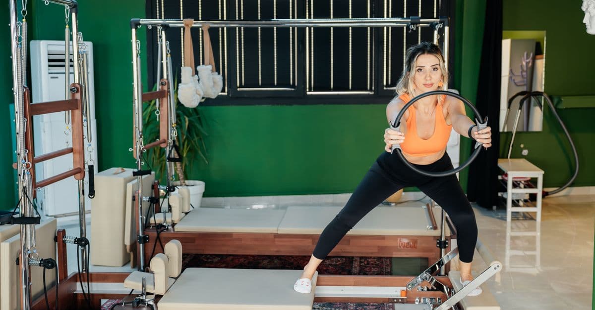 Bir pilates stüdyosunda reformer cihazı üzerinde egzersiz yapan kadın