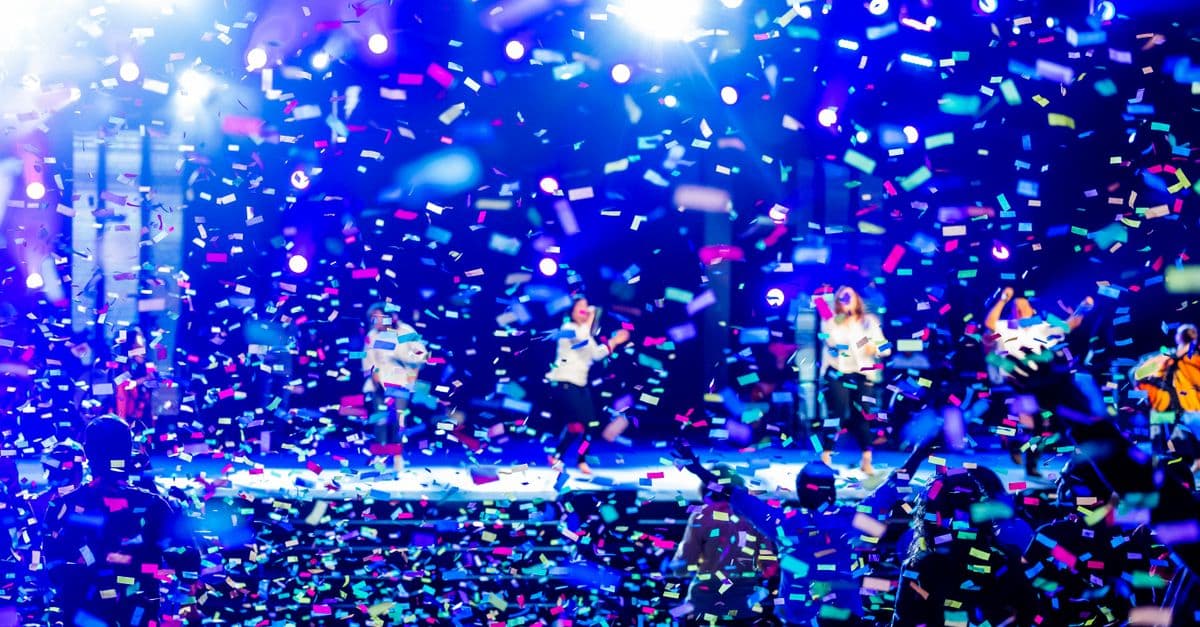 Bir K-pop sahne performansını andıran renkli ışıklı konser görüntüsü