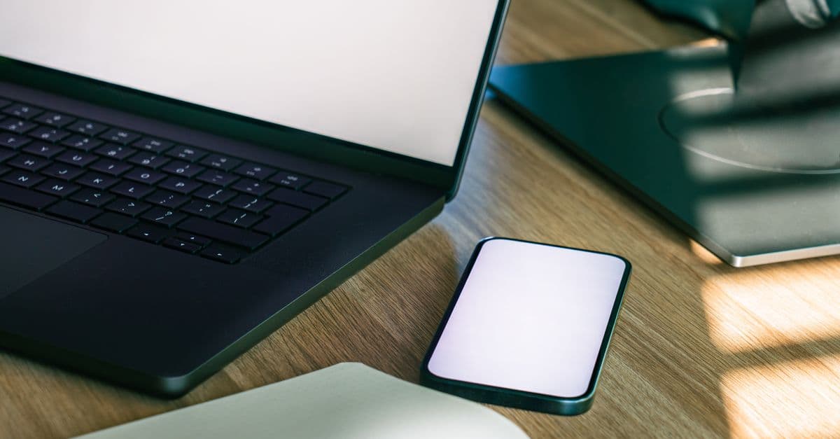 Telefonla çalışan bir kullanıcının güvenlik ayarlarını kontrol ettiği masa