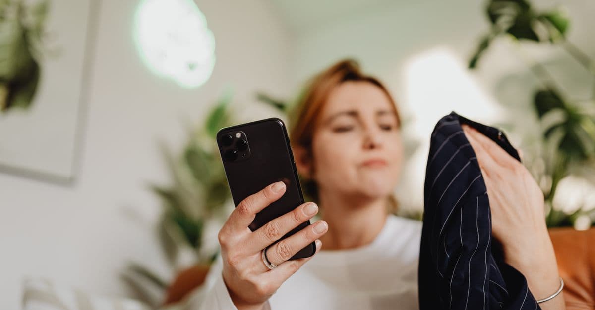 Telefonuna bakan ve rahatsız görünen genç bir kadın