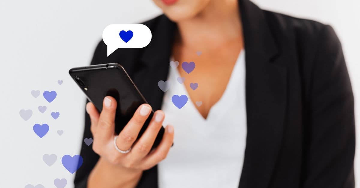Bir akıllı telefon ekranında kalp emojili sosyal medya paylaşımı